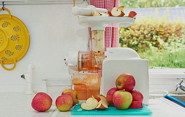 บีบน้ำจากแอปเปิ้ลด้วยเครื่องคั้นน้ำผลไม้