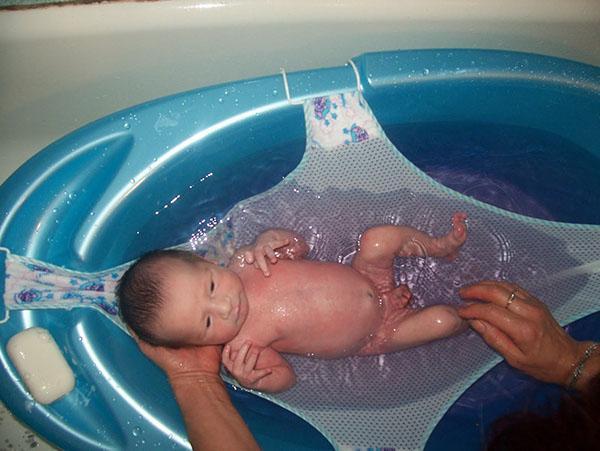 badning af en nyfødt i en hængekøje